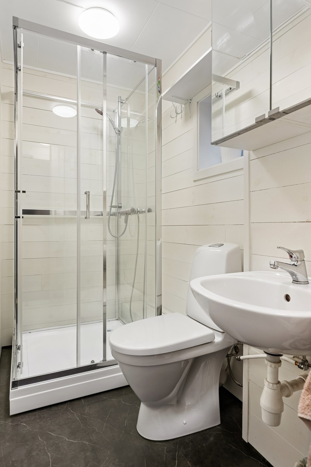 Baderommet i 1. etasje er innredet med servant, dusjkabinett og toalett. Galleribilde