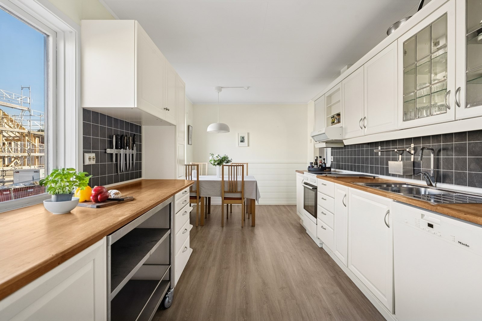 Lyst og pent kjøkken med praktisk utforming og rikelig med både benke- og skapplass. Galleribilde