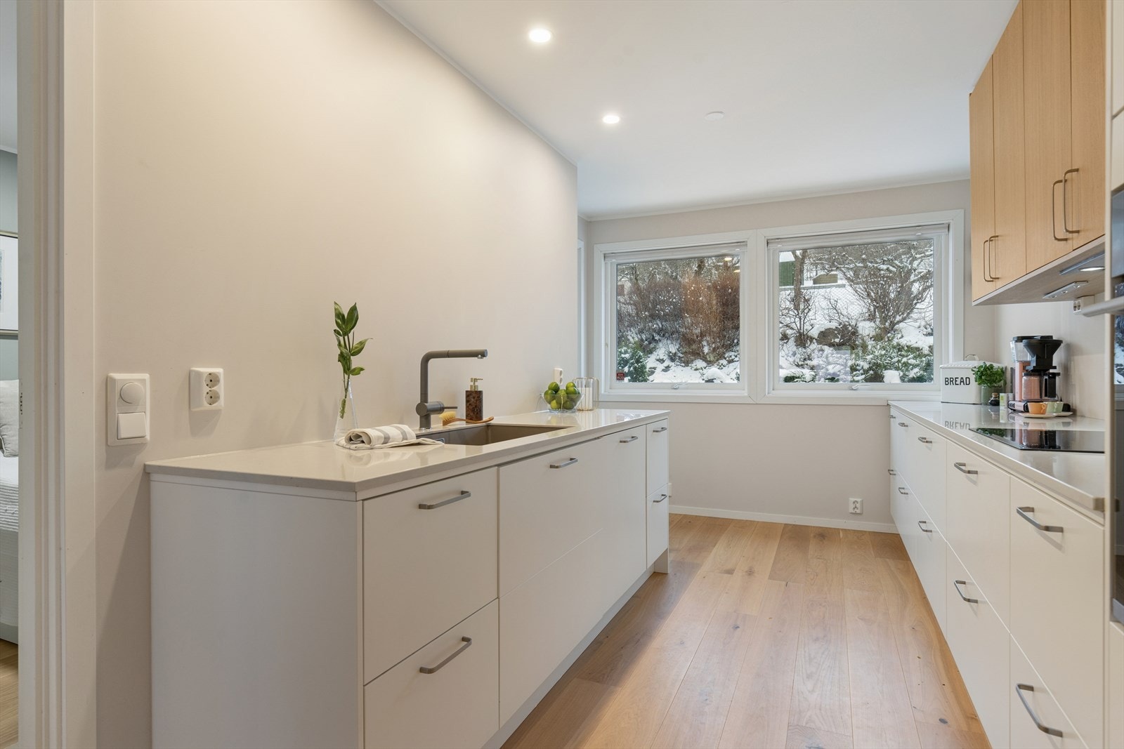 Kjøkken med masse benk og skapplass - innredet med glatte fronter. Galleribilde