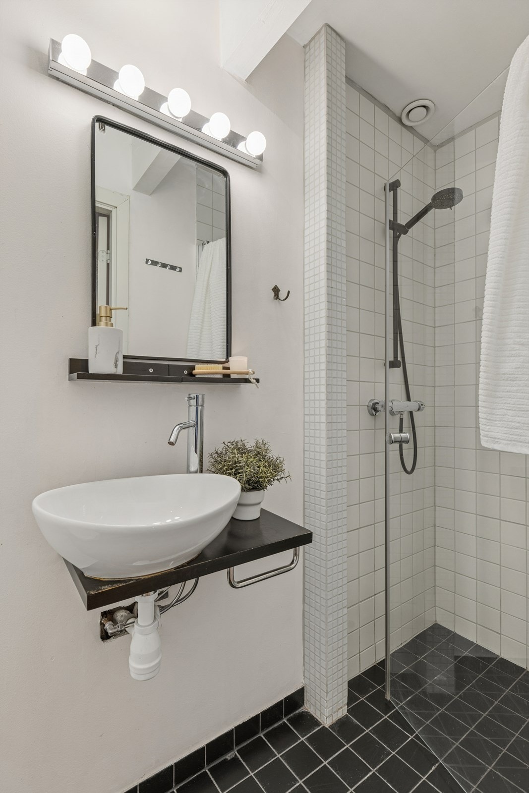 Flislagt bad i 1. etasje med toalett, servant og dusj på vegg. Galleribilde