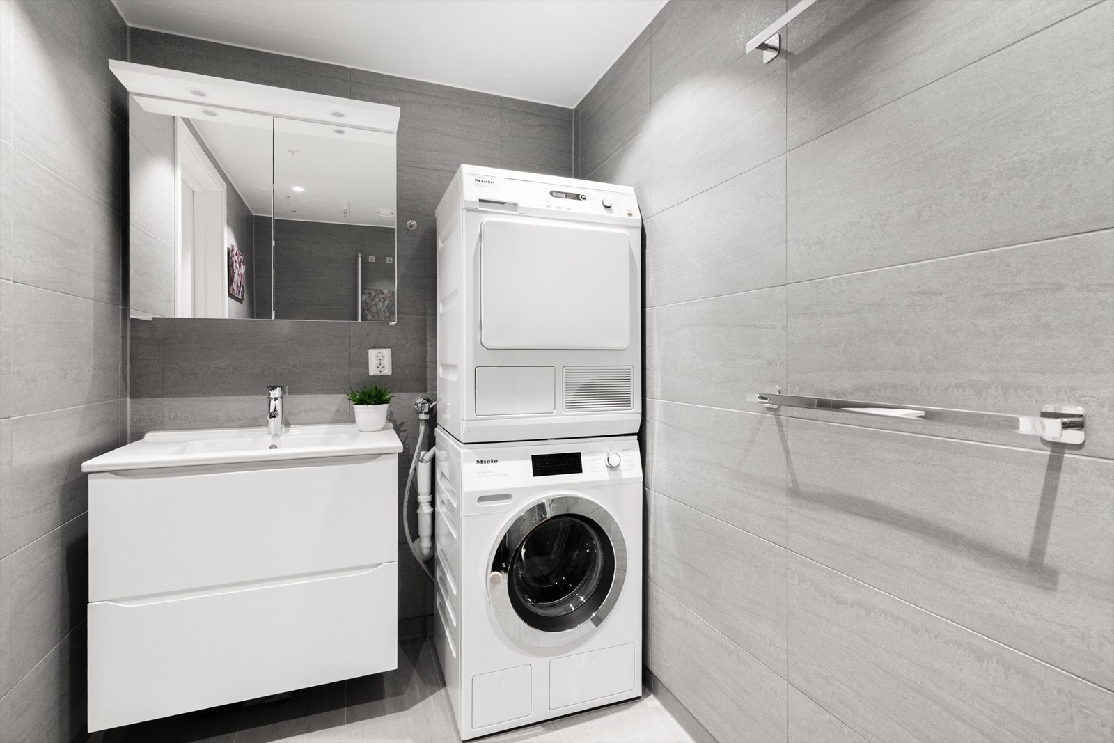 Hovedbadet har adkomst direkte fra hovedsoverommet. Badet er innredet med veggmontert toalett, dusjhjørne og servantinnredning med skuffer og speilskap med overlys. Galleribilde