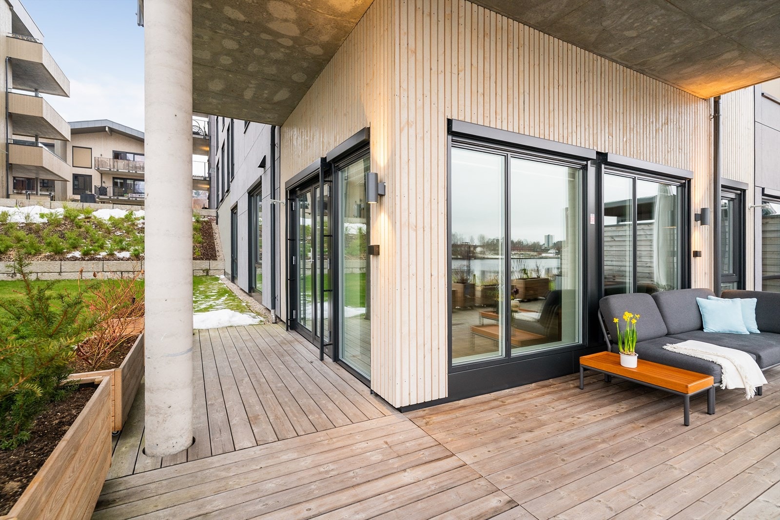 Stor delvis overbygget vinkleterrasse, hvor det er rikelig plass for flere sone med sittegrupper. Galleribilde