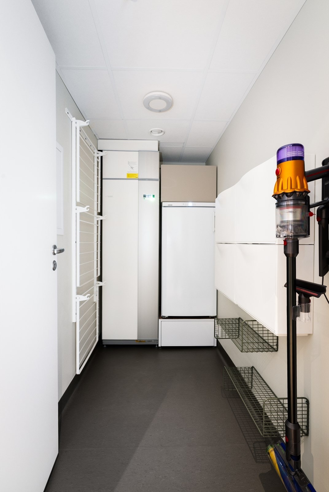Praktisk bodrom/teknisk rom innredet med tørkestativ, skap og hyller. Her er NIBE varmepumpe og ventilasjonsanlegg plassert. Galleribilde