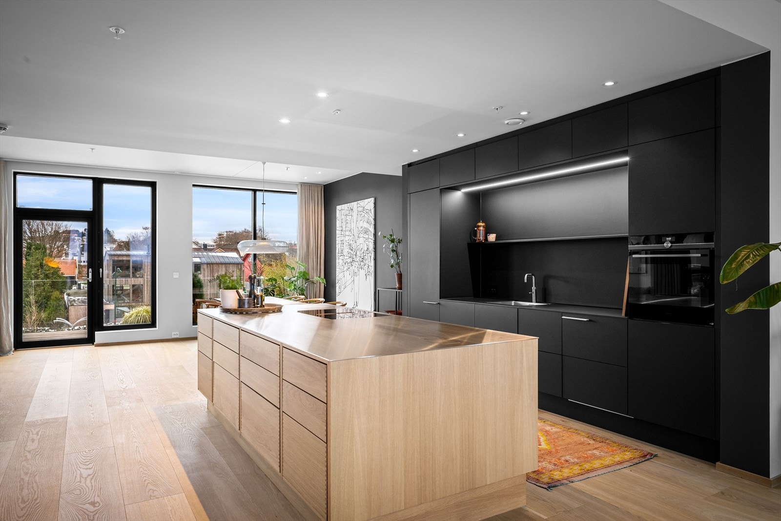 Delikat oppgradert kjøkken med bl.a skap til tak, dobbel bredde på kjøkkenøyen og med eikeskuffer, slank stål benkeplate, Quooker, planlimt vask og integrerte Siemens-hvitevarer. Stramt og mykt på samme tid. Galleribilde