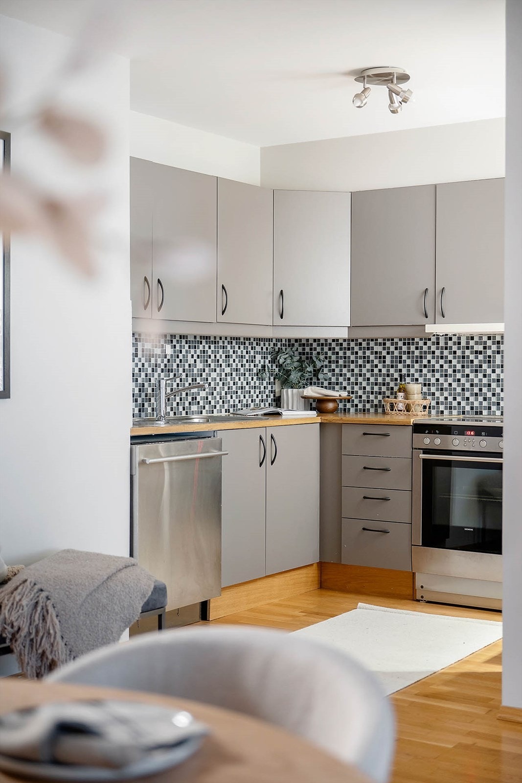 Kjøkken med god benkeplass og praktisk utforming som gir effektiv arbeidsflyt. Flislagt vegg og rikelig med skapplass. Galleribilde