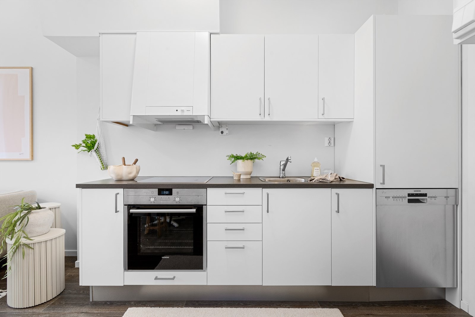 Kjøkkeninnredningen har lyse, glatte fronter med benkeplate av laminat. Galleribilde