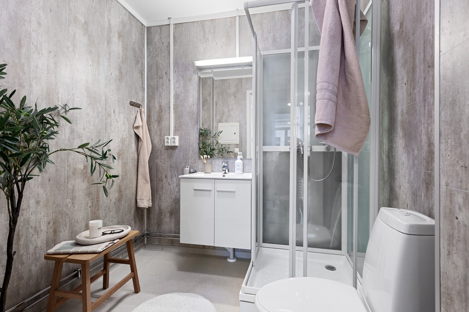 Det er baderomsplater på veggene, taket er malt og gulvet har vinylbelegg. Badet har en panelovn som varmekilde. Galleribilde