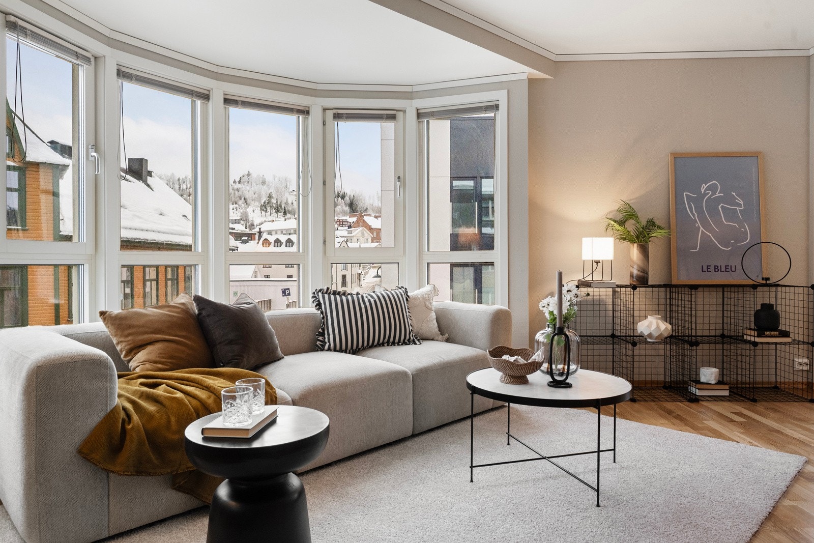 De buede vinduene i stuen gir rommet et unikt særpreg og slipper inn rikelig med lys, som skaper en luftig og innbydende atmosfære. Galleribilde