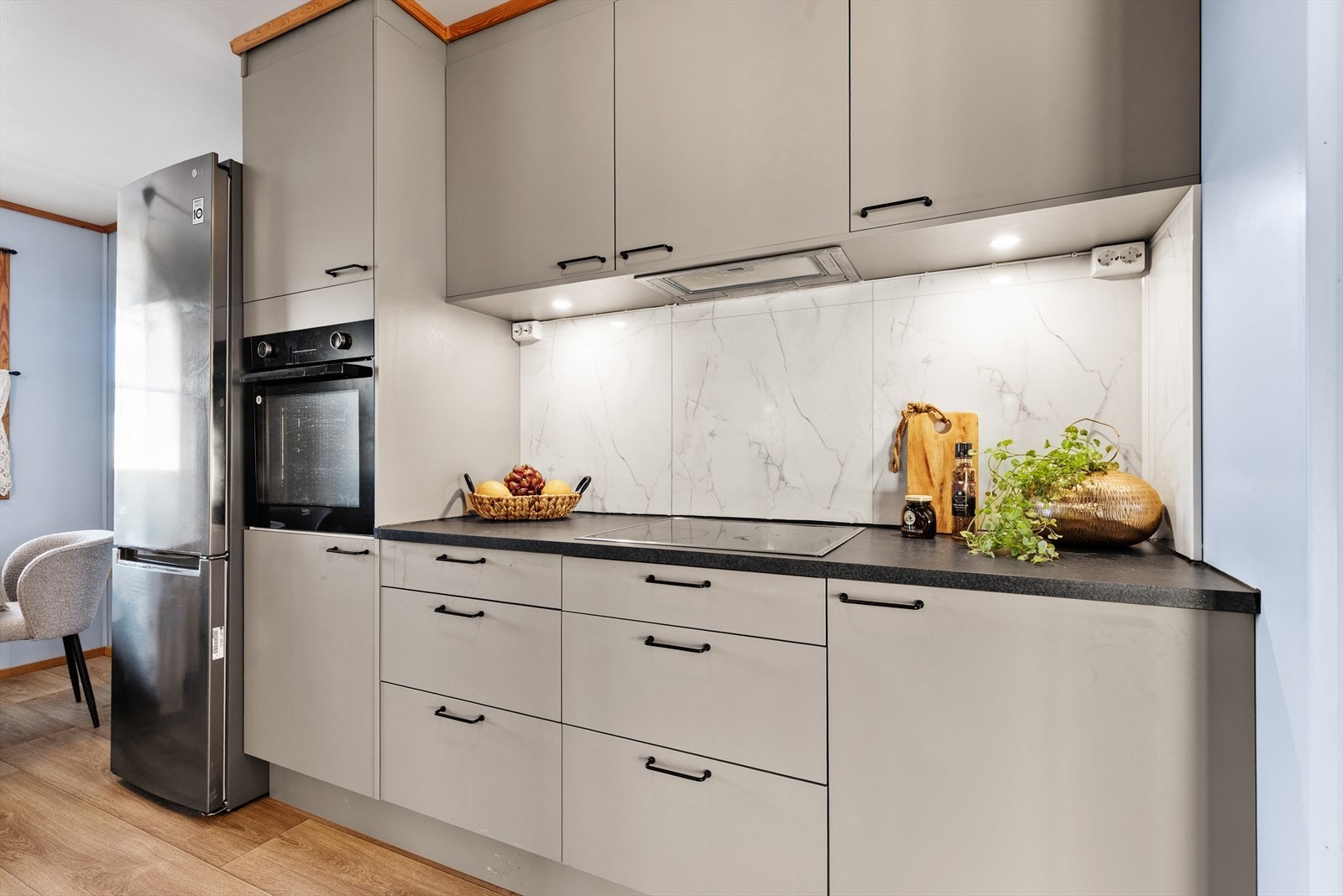 Kjøkkeninnredningen har glatte fronter og er utstyrt med integrert stekeovn og platetopp. Galleribilde