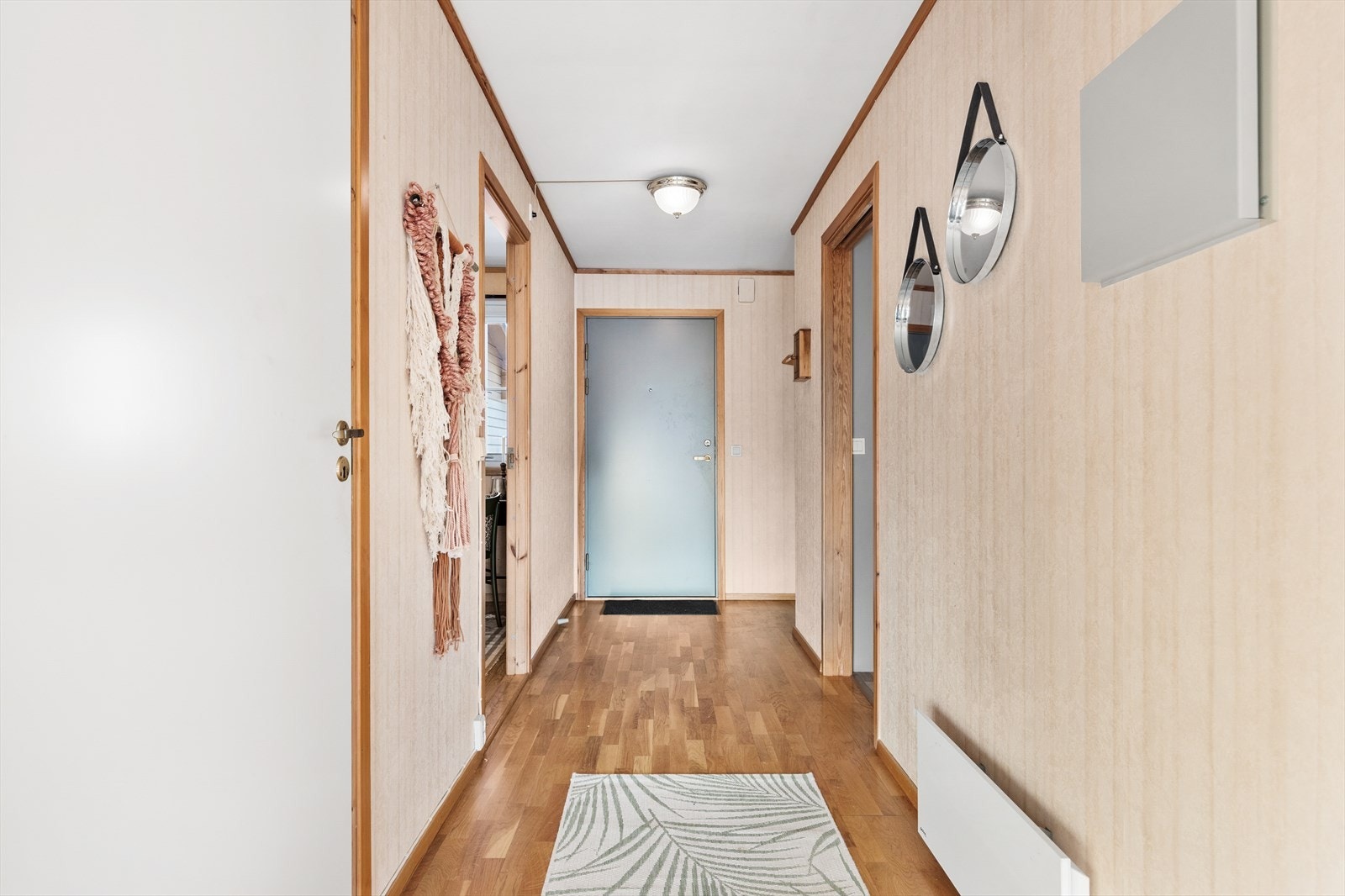 Gangen har parkett på gulv og leder deg videre inn i leiligheten. Galleribilde