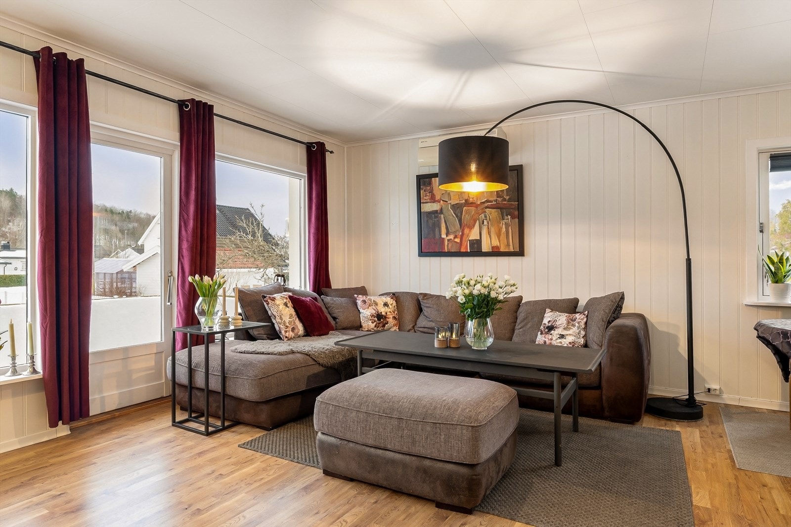 Lys vinkelstue med peisovn og utgang til terrasse Galleribilde