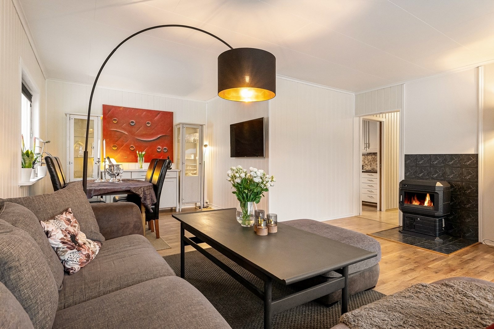 Lys vinkelstue med peisovn og utgang til terrasse Galleribilde