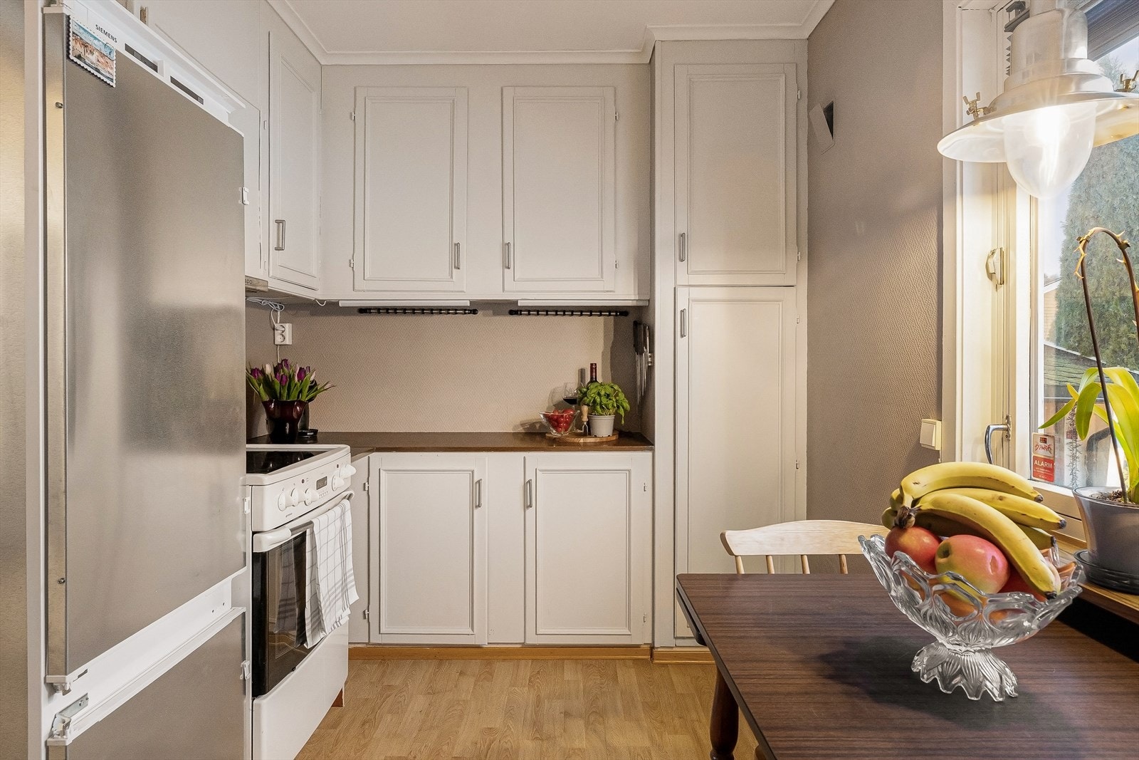 Praktisk kjøkken med takhøye overskap Galleribilde