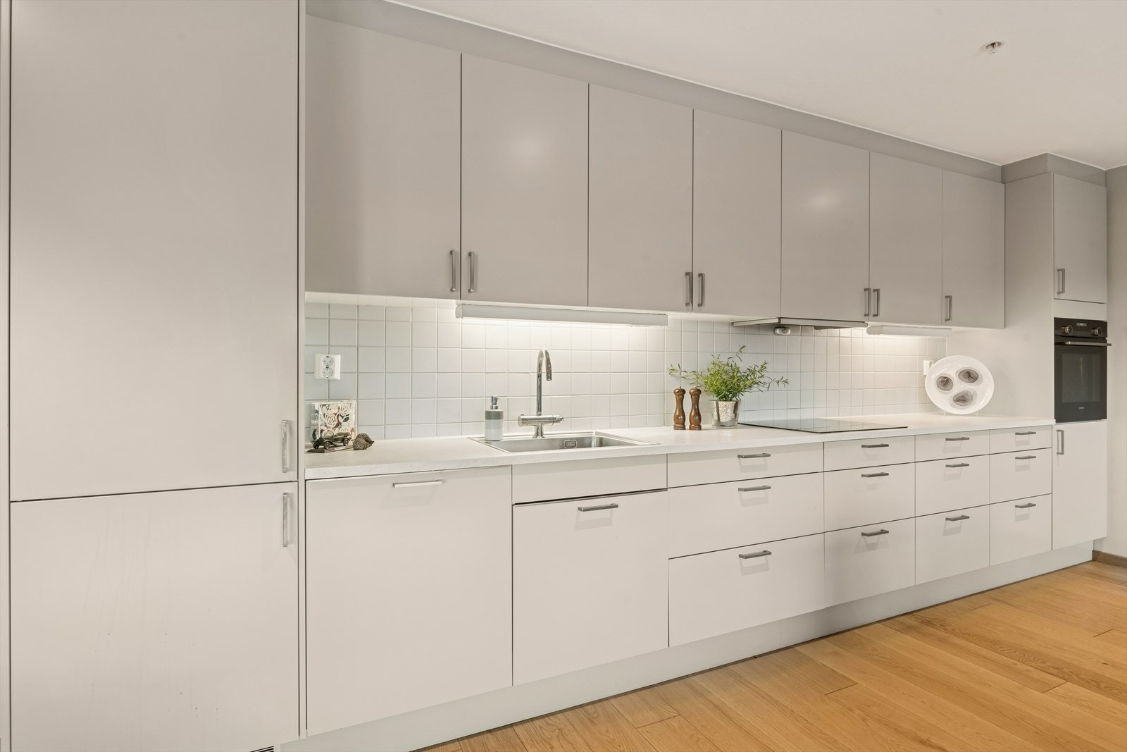 Kjøkkenet har integrerte hvitevarer og rikelig med lagring i skuffer og skap. Galleribilde