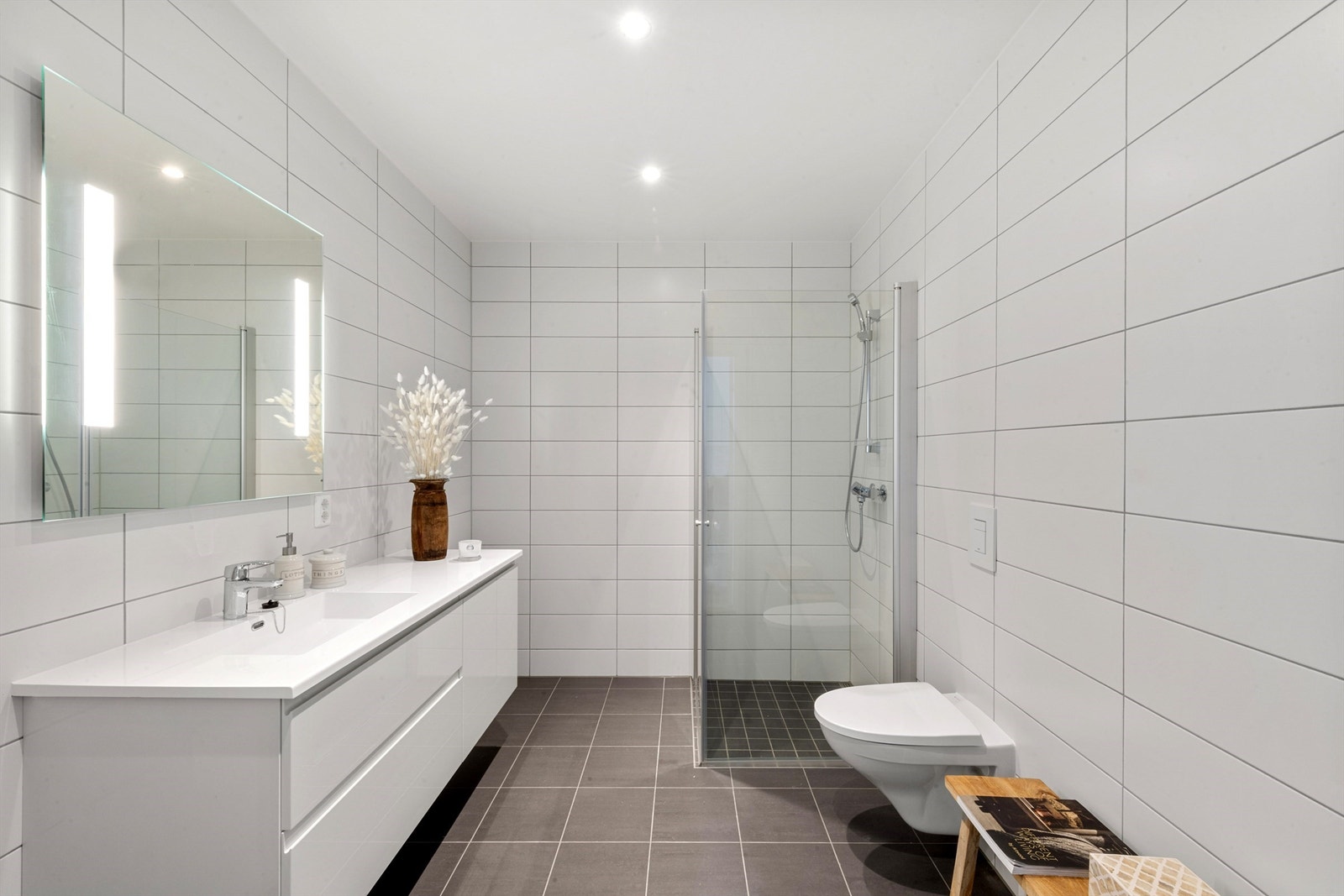 Leiligheten har et pent badet med flislagte overflater, gulvvarme, mekanisk avtrekk og downlights Galleribilde