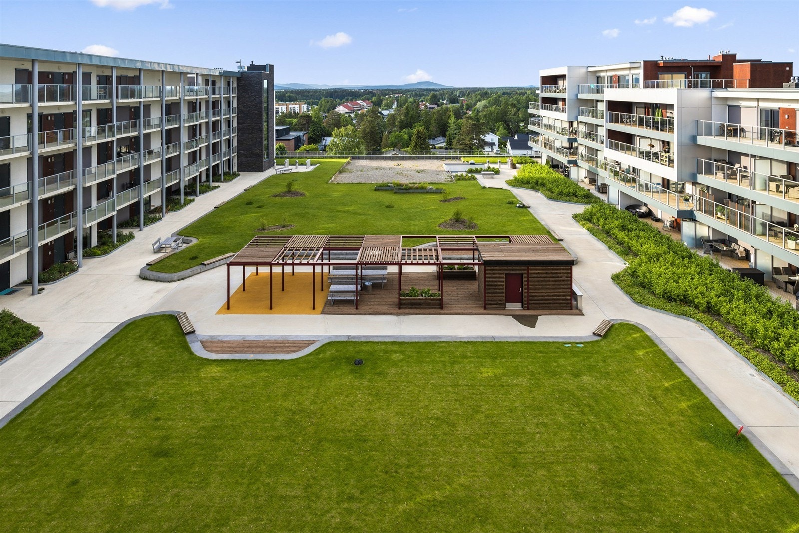 Her er det pent opparbeidet med grøntarealer, gangstier og fine sittegrupper Galleribilde