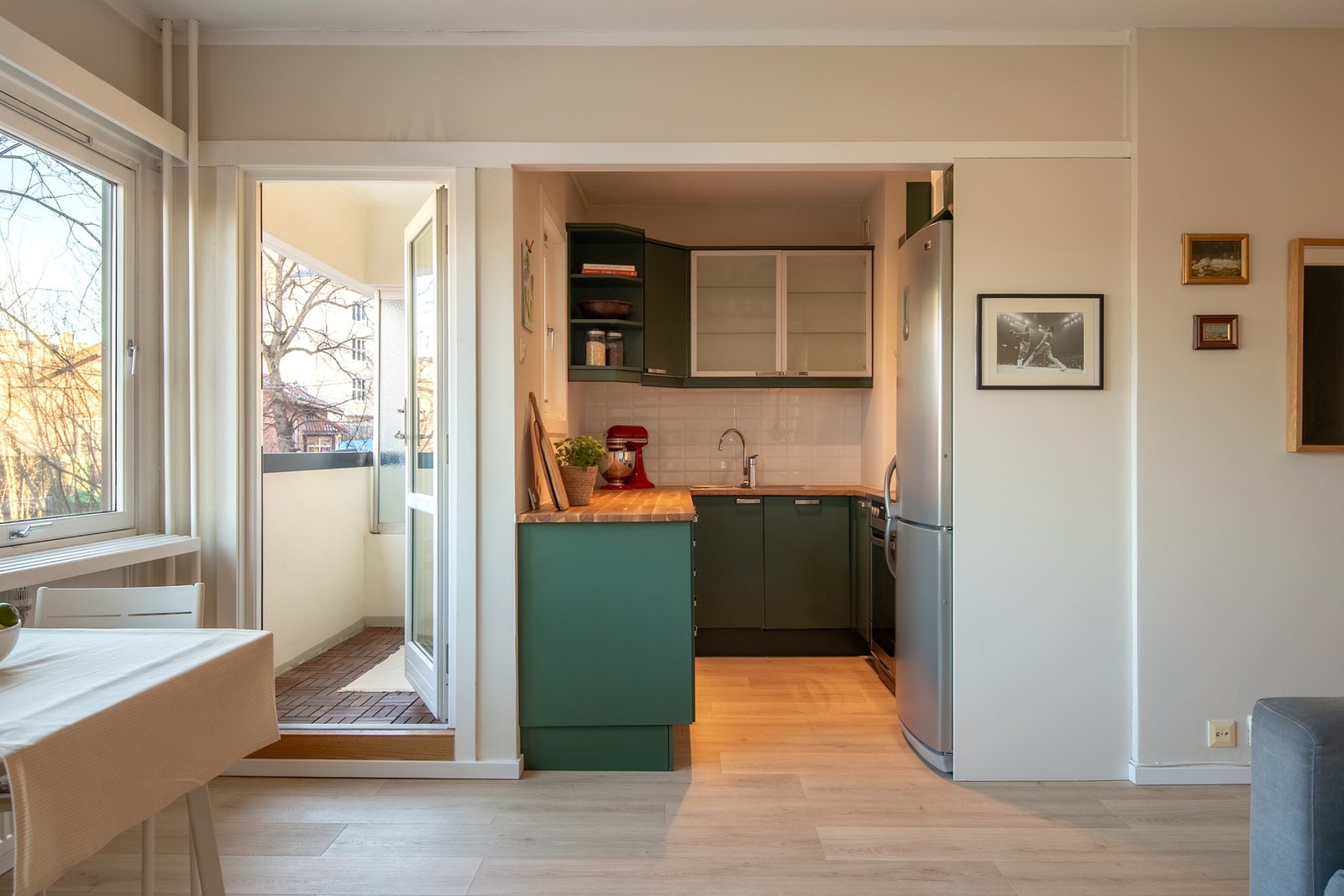 Den åpne løsningen mot et stilfullt kjøkken skaper en harmonisk flyt mellom rommene og legger til rette for sosialt samvær. Galleribilde