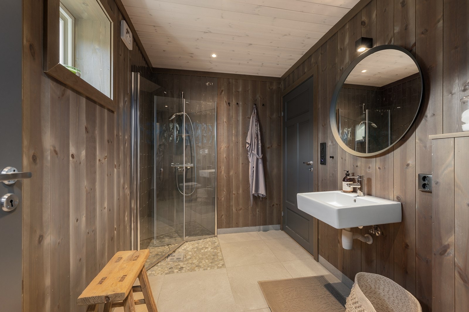 Hovebadet, delikat baderom med flislagt dusj med innfellbare glassdører. Samme gjennomførte stil på begge badene. Galleribilde