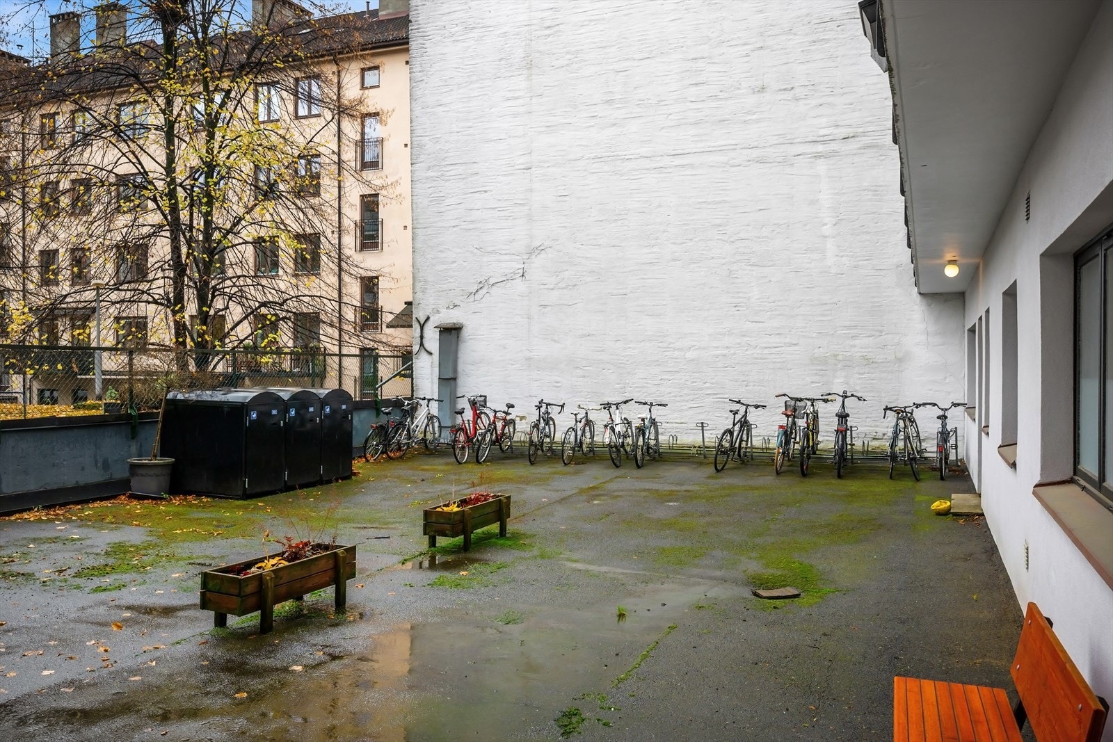 Lukket bakgård med sykkelparkering, vognparkering og sittegrupper. Galleribilde