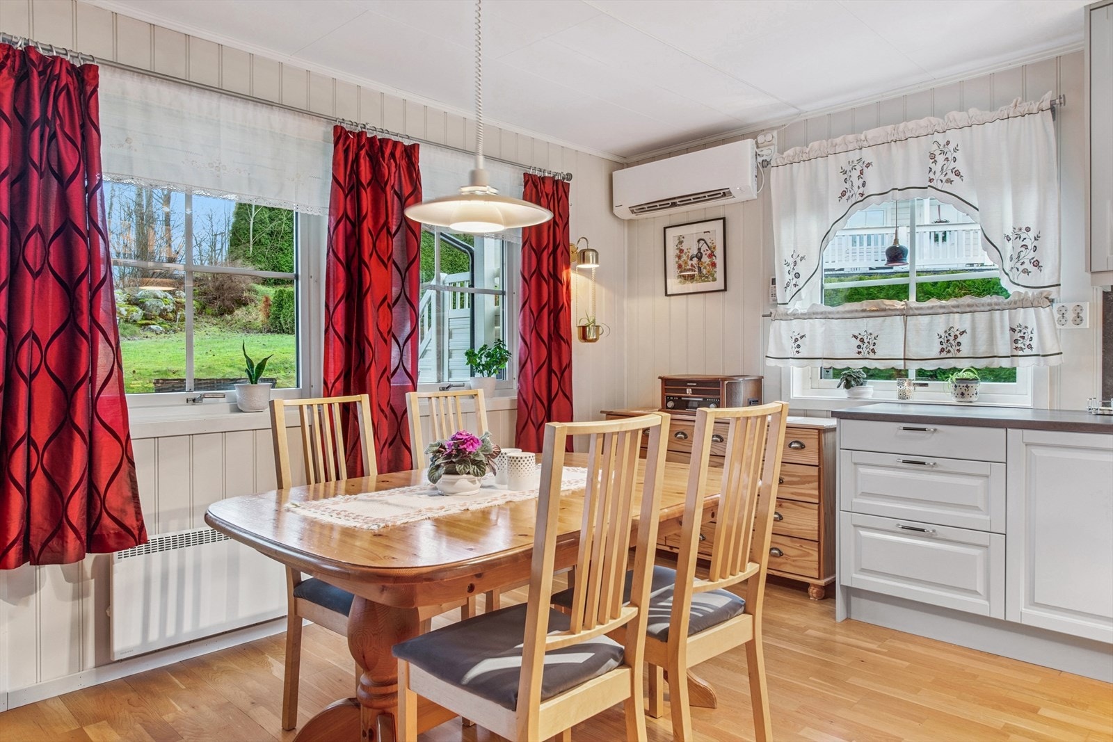 Vinduer over spiseplassen og kjøkkenbenken gir godt med arbeidslys. Varmepumpen gir god og stabil varme. Galleribilde