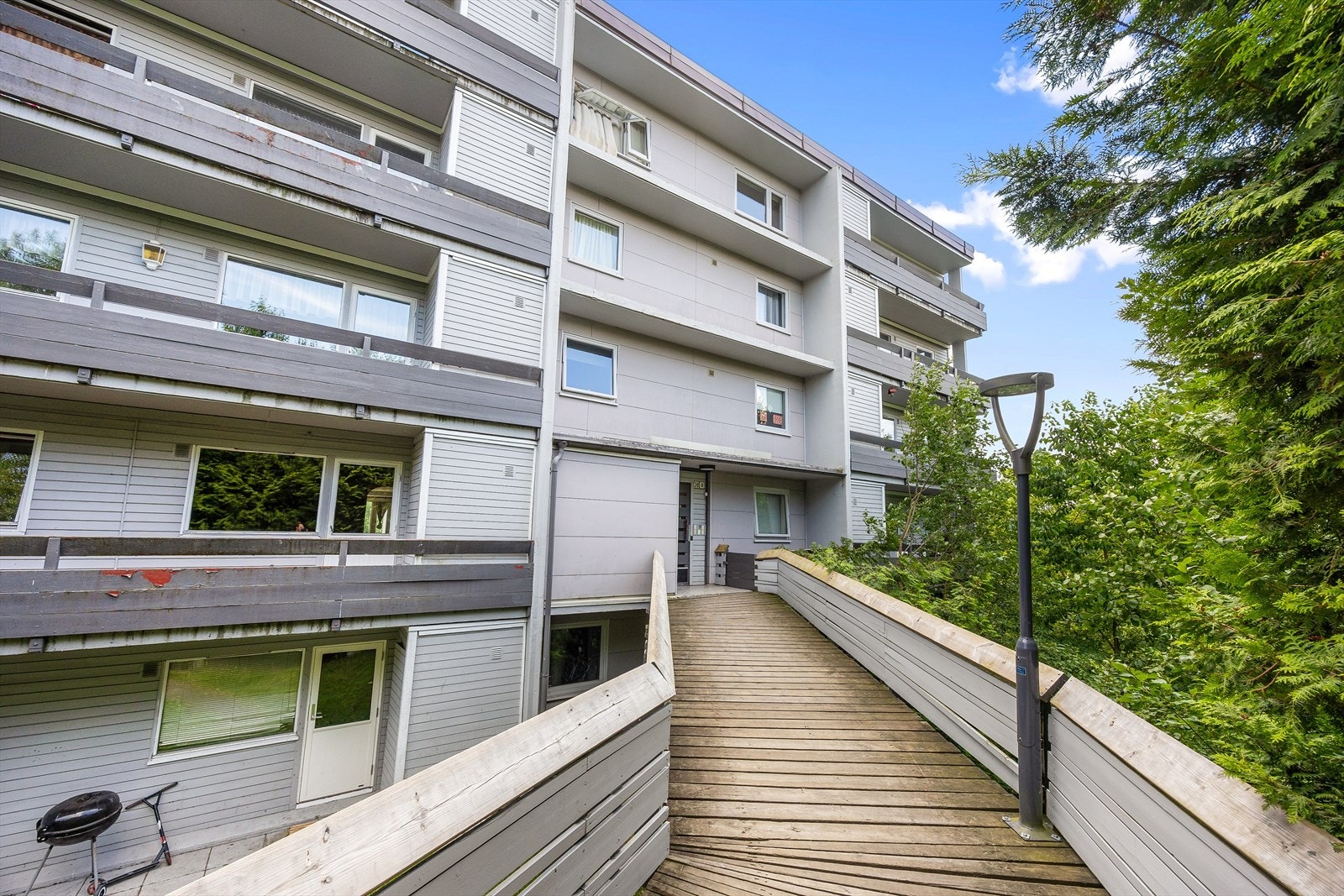 Velholdt fasade med panel og adkomst via felles trapper. Galleribilde