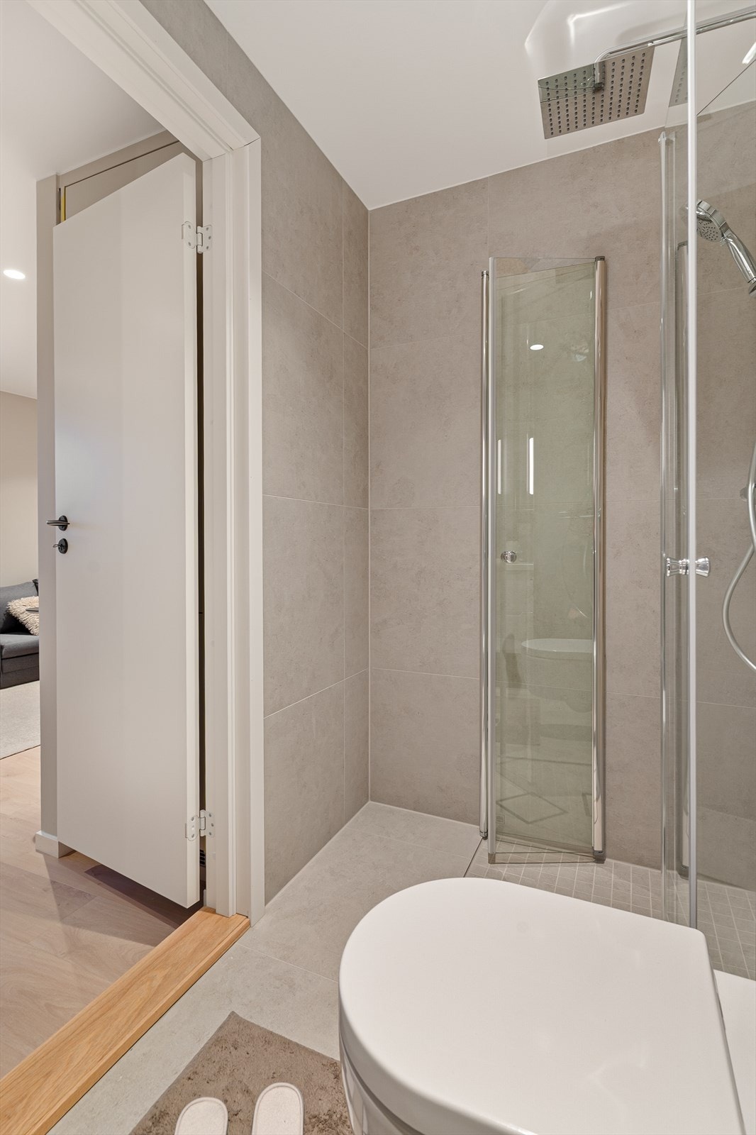 Dusjhjørne med innfellbare dører i herdet glass og moderne armatur. Galleribilde