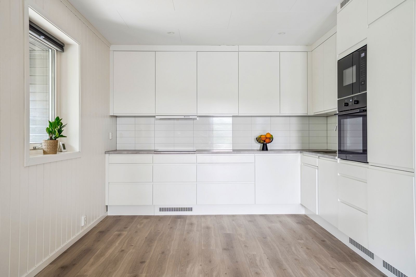 Stilrent hjørnekjøkken fra EPOQ. Moderne innredning i hvite, glatte fronter - et tidløst uttrykk med rene linjer. Galleribilde