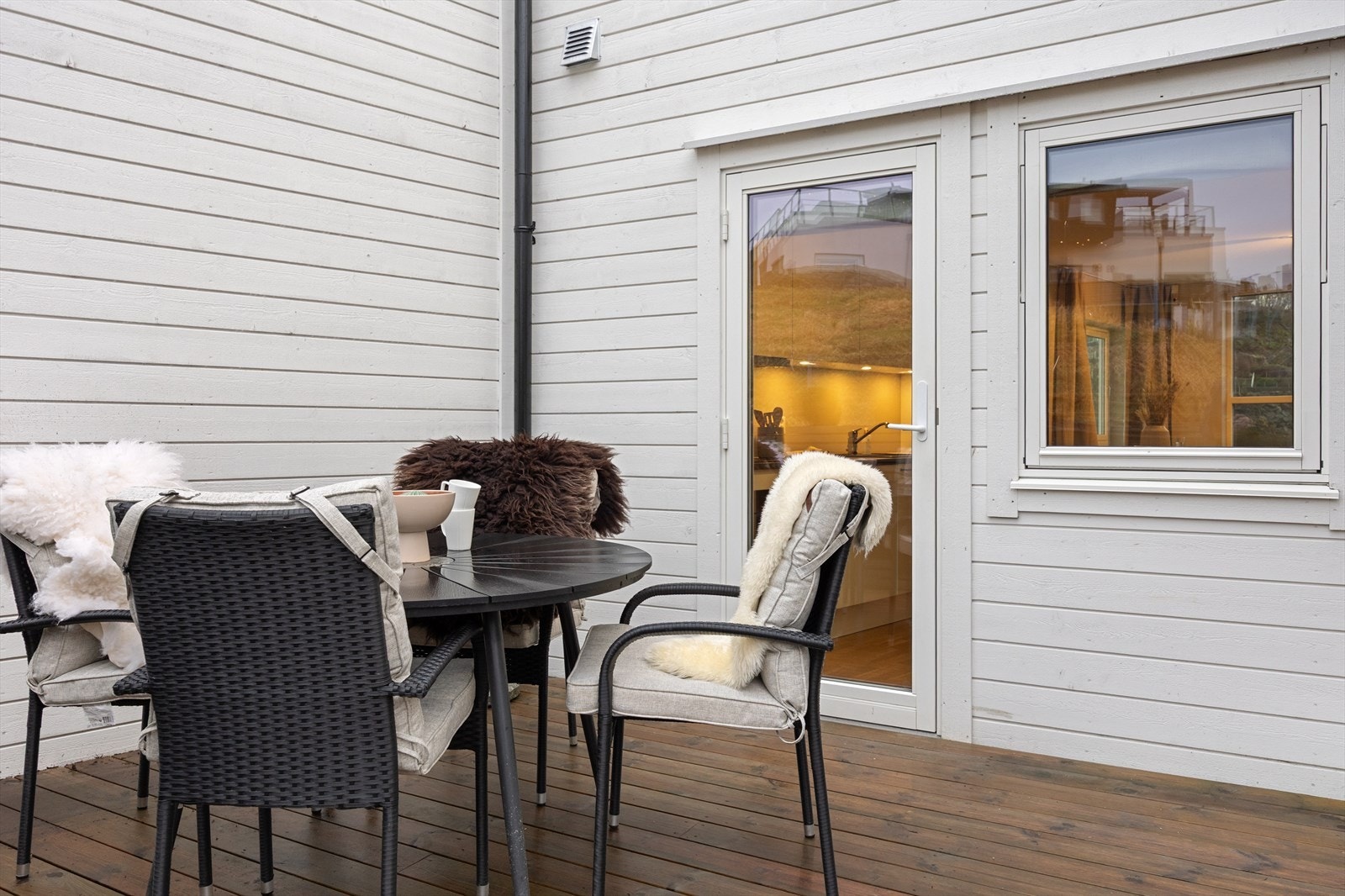 Fra kjøkkenet kan man gå direkte ut på terrassen i front av boligen. Galleribilde