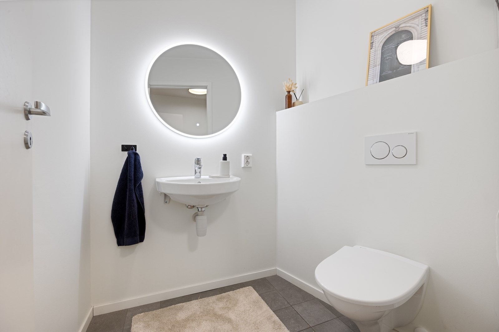 Praktisk wc-rom med keramiske fliser på gulv og malte slette vegger. Galleribilde