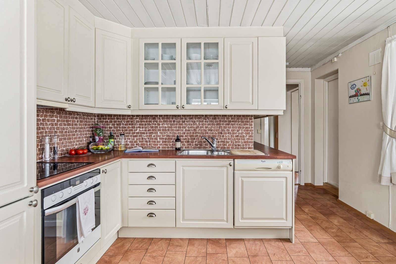 Det er satt opp tromlede marmorfliser på veggen over benkeplaten. Galleribilde