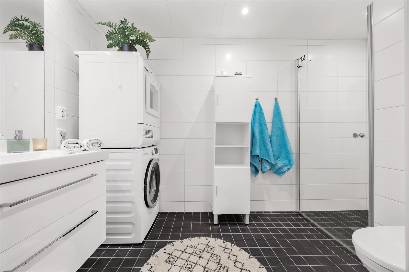 Badet er helfliset og har en hvit servantinnredning med praktiske skuffer. Galleribilde