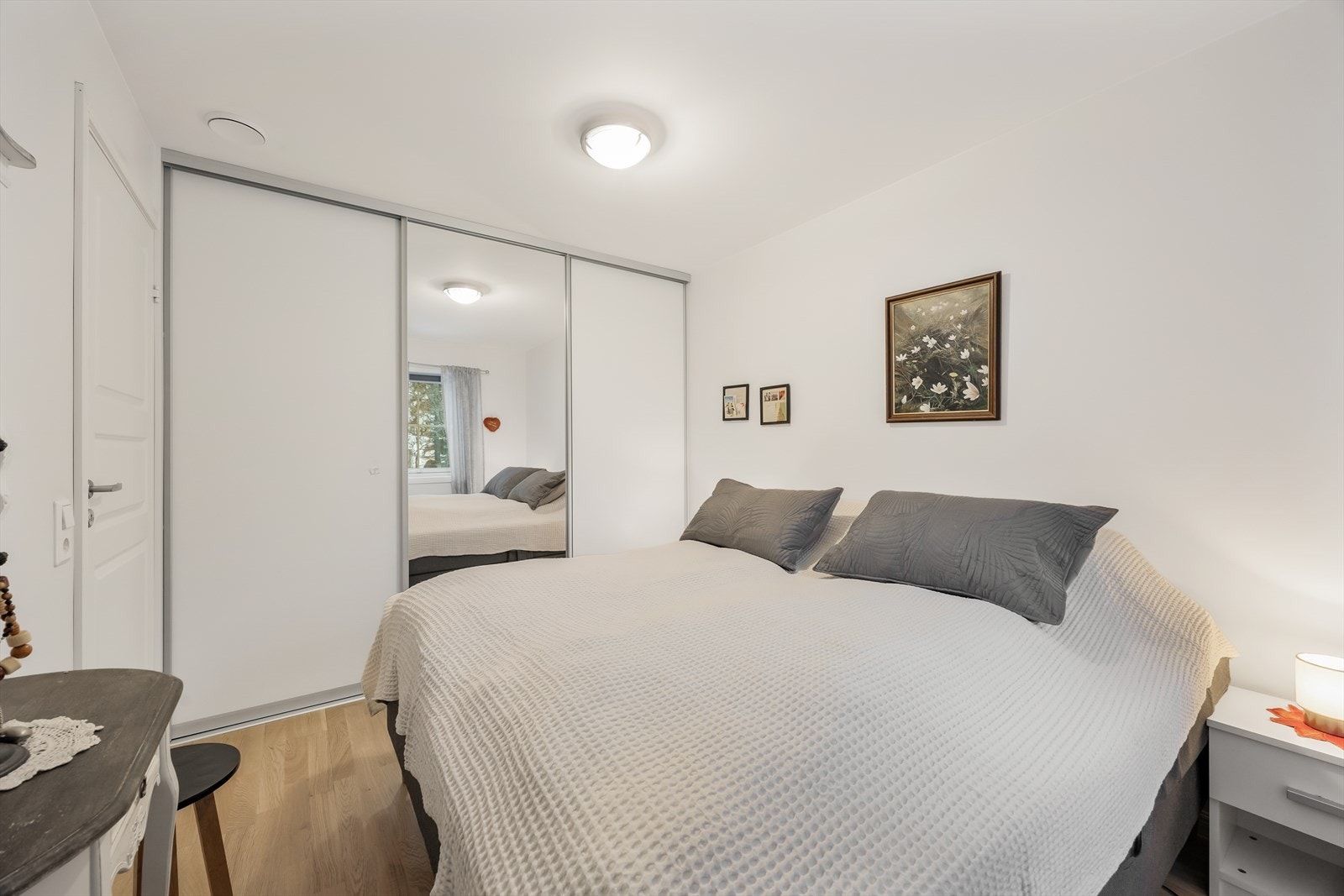 En stor skyvedørsgarderobe med speilfronter gir rikelig med oppbevaringsplass. Galleribilde