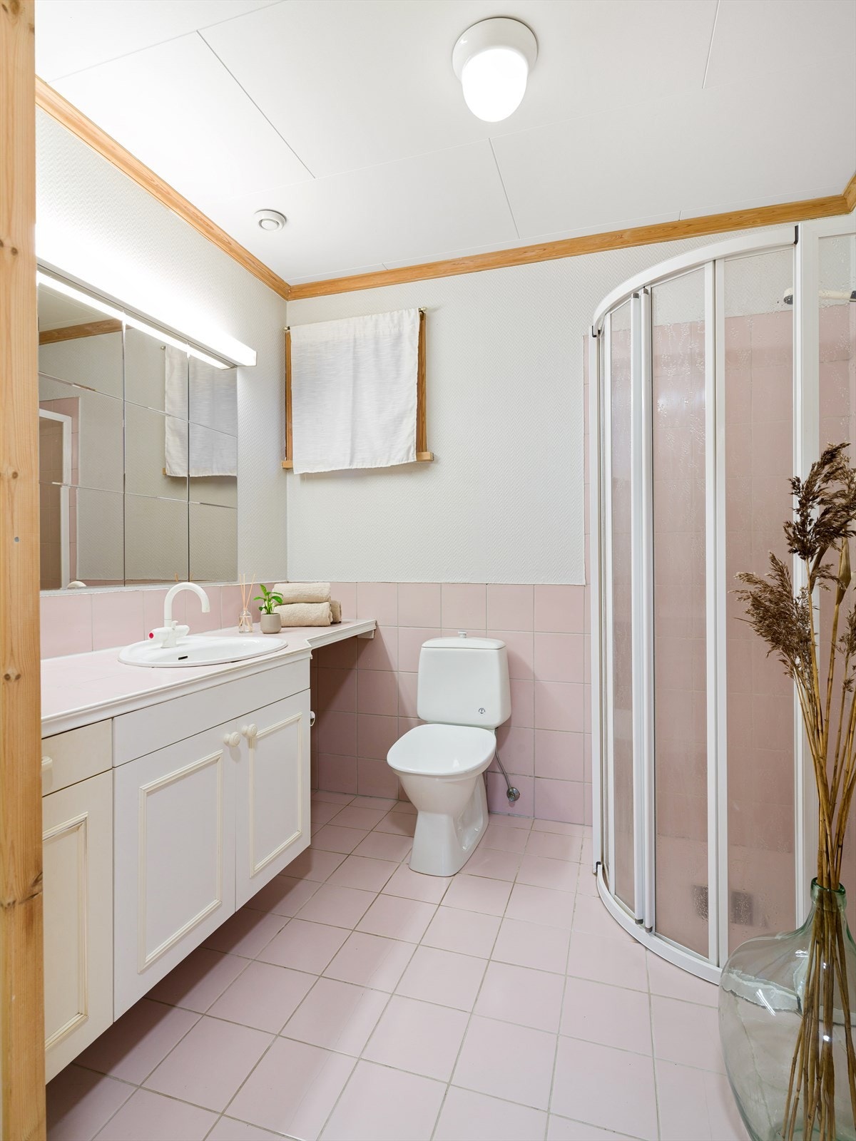 Bad med fliser på gulv og i dusjsonen. Dusjhjørne, wc og vask i seksjon. Varmekabler i gulv. Galleribilde