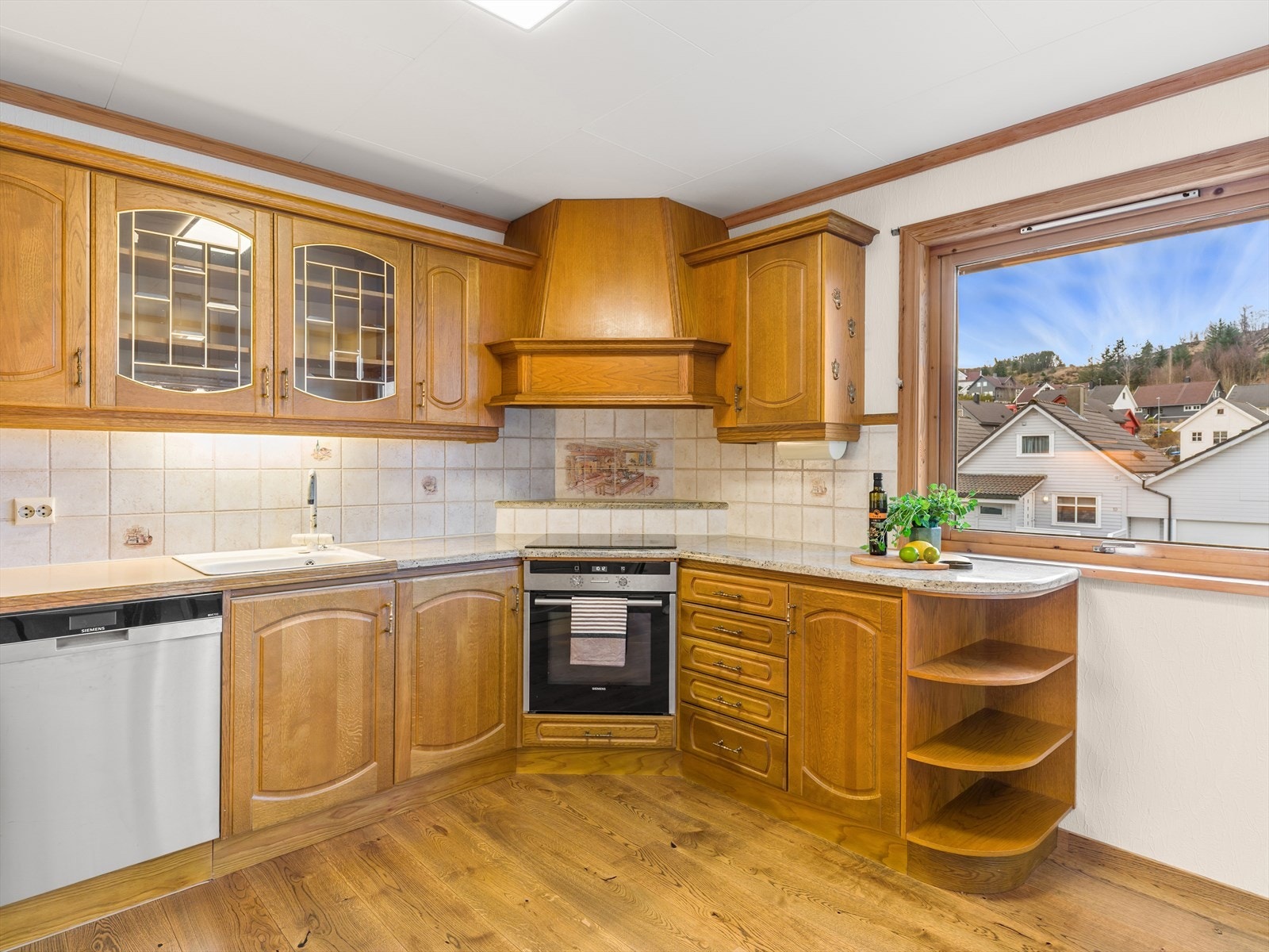 Kjøkken med dører i eik. Fliser og belysning over benk. Galleribilde