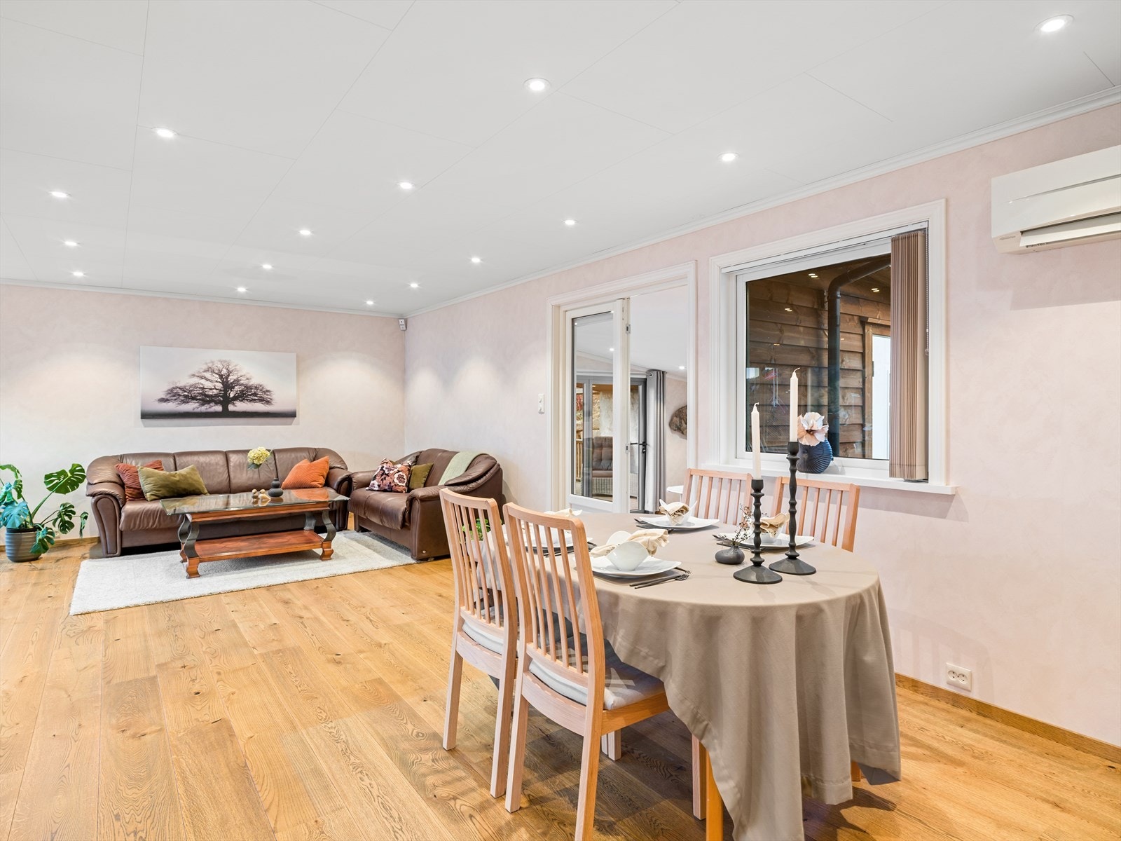 Romslig vinkelstue med enstavs parkett, lyse vegger og spotter i tak. Galleribilde