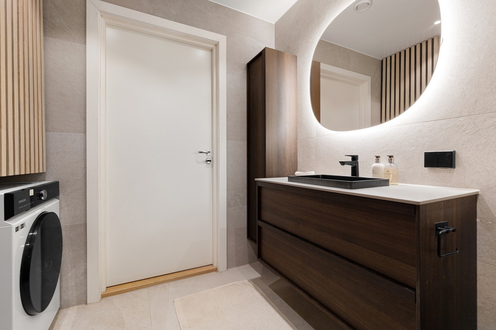 Badet er innredet med Haven baderomsmøbler og veggmontert toalett fra Villeroy & Boch, stilren servantløsning med god oppbevaringsplass, dusjnisje med glassvegger samt opplegg for vaskemaskin. Galleribilde