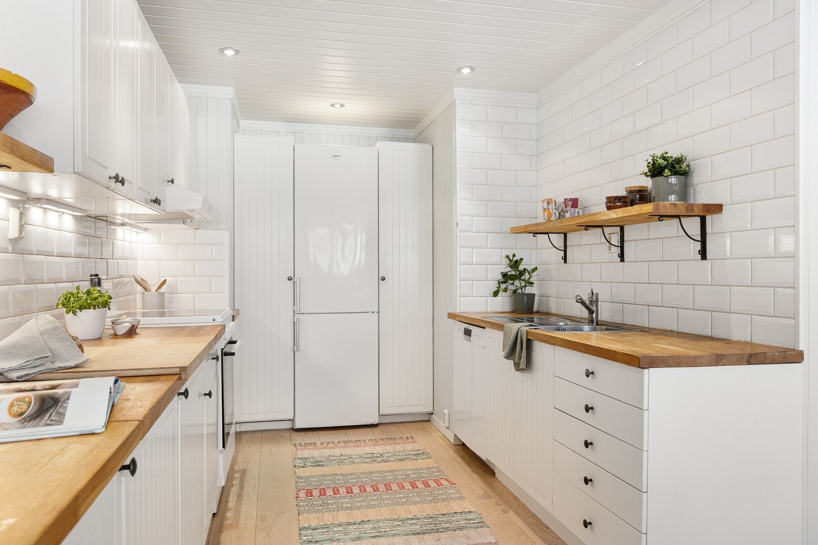 Det er nisje for komfyr og oppvaskmaskin i benk, og ventilator er integrert i overskap. Galleribilde