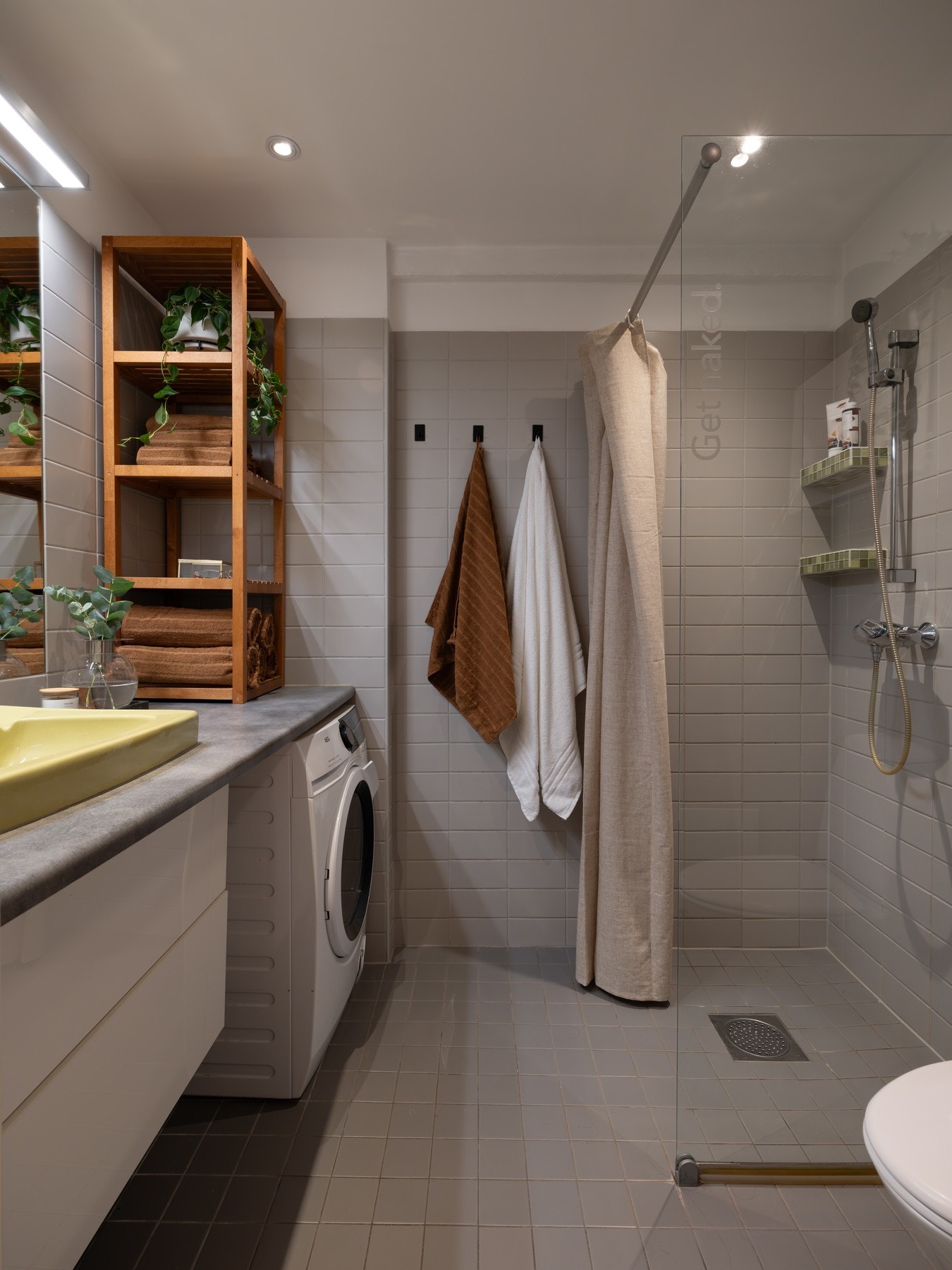 Delikat flislagt baderom med tidløse grå fliser, samt downlights i himlingen og varmekabler på gulv. Galleribilde