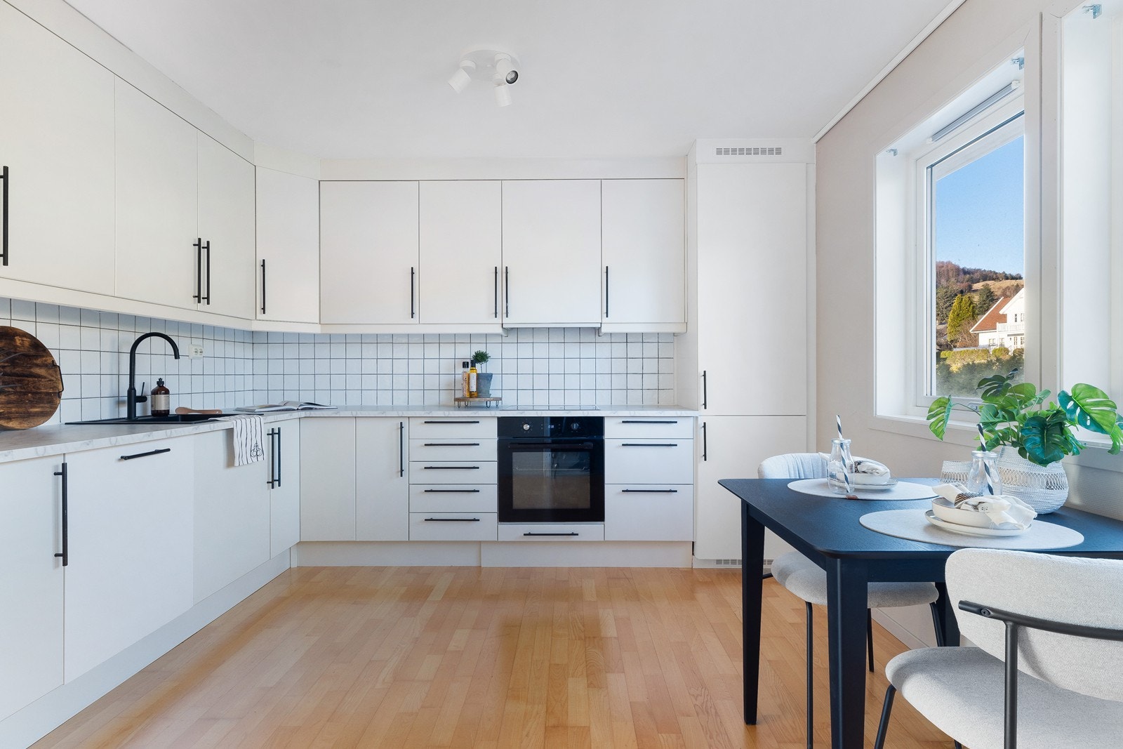 Fliser mellom benkeplate og overskap gir kjøkkenet et funksjonelt design. Galleribilde