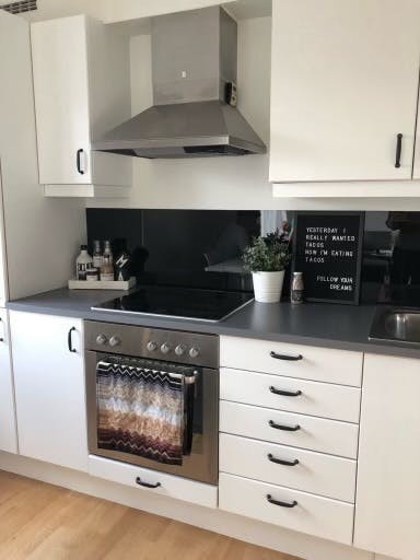 Lyst og pent kjøkken med integrerte hvitevarer. Galleribilde