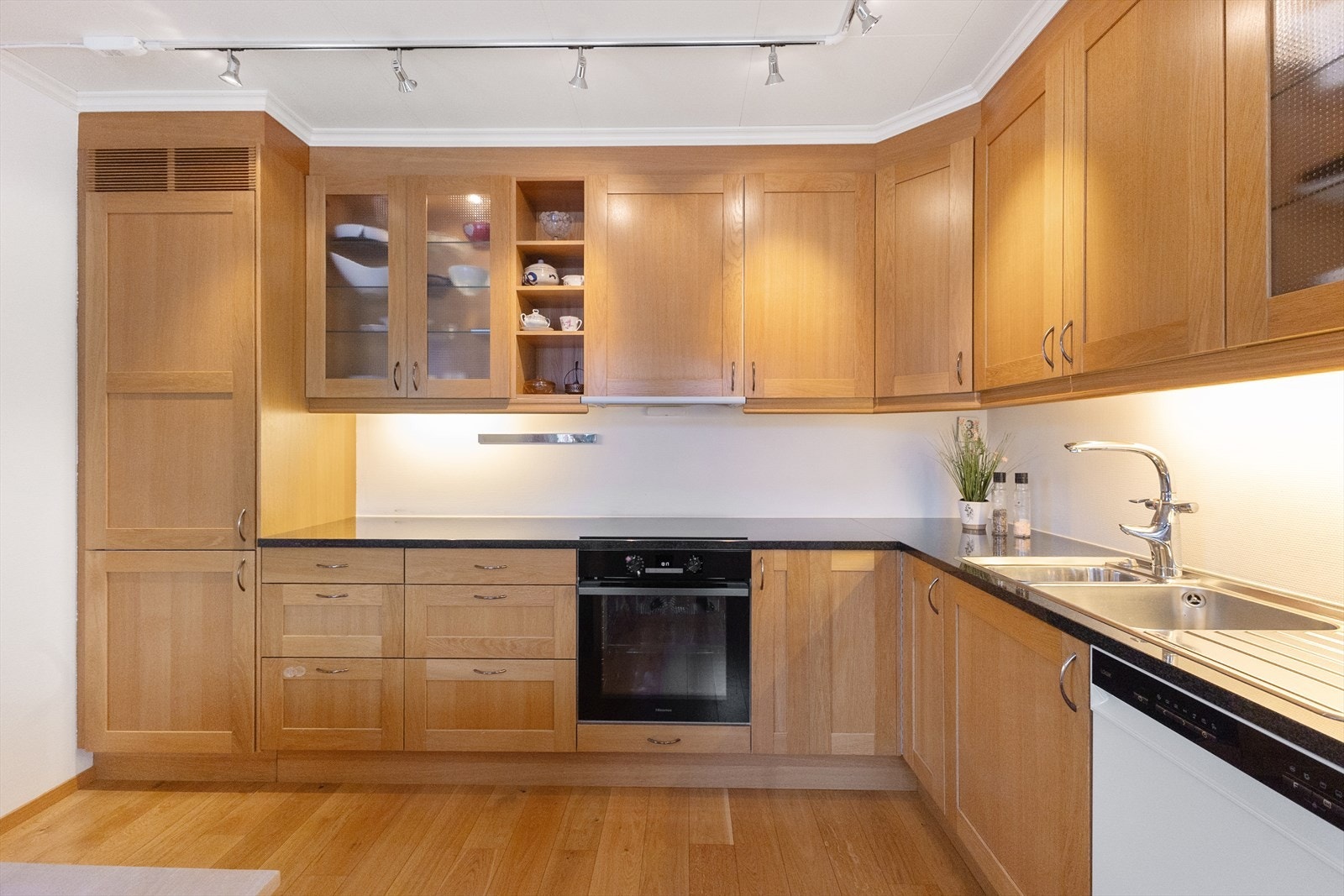 Pent kjøkken med nyere hvitevarer. Benkeplaten er av stein/granitt. Galleribilde