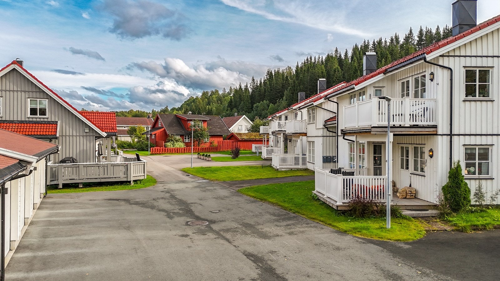 Garasjerekken ser man til venstre på bildet. Her er det ingen gjennomgangstrafikk. Det er godt med p-plasser for besøkende på eiendommen til borettslaget. Galleribilde