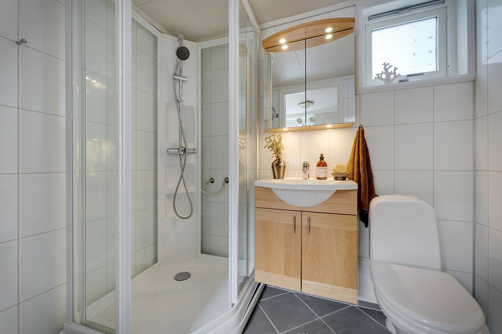 Praktisk bad med dusjkabinett, servant og toalett. Galleribilde
