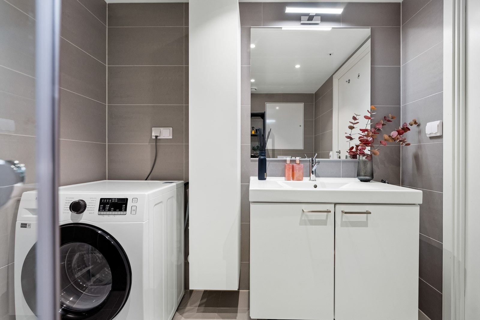 Opplegg for vaskemaskin er etablert, og badet har vegghengt toalett, vannbåren gulvvarme og et dusjhjørne med innfellbare glassdører. Galleribilde