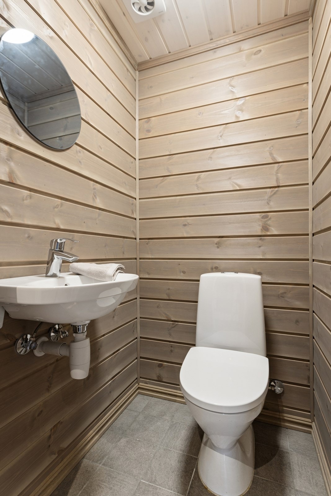 Separat wc-rom med panel på vegger og tak, samt flislagt gulv. Galleribilde