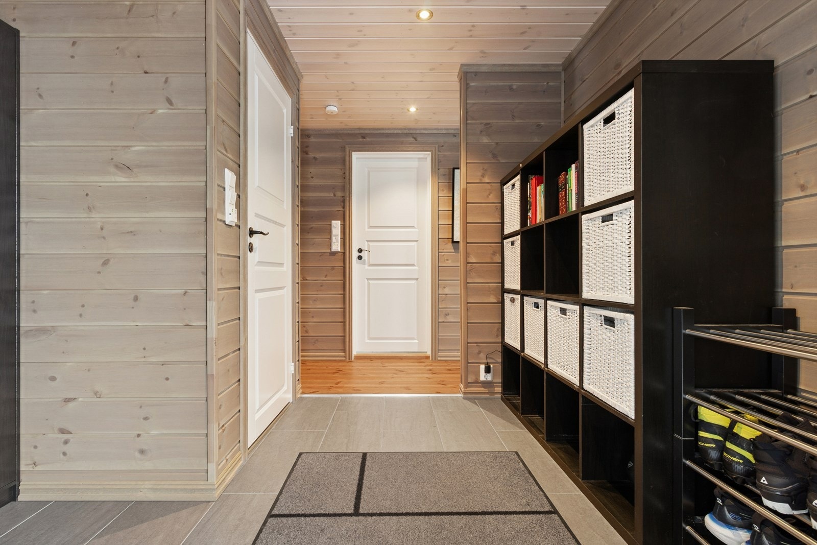 Innenfor døren blir du møtt av en romslig flislagt entrè, med trepanel på veggene, og fliser med varme på gulv. Her finner man også separat toalett rom. Galleribilde