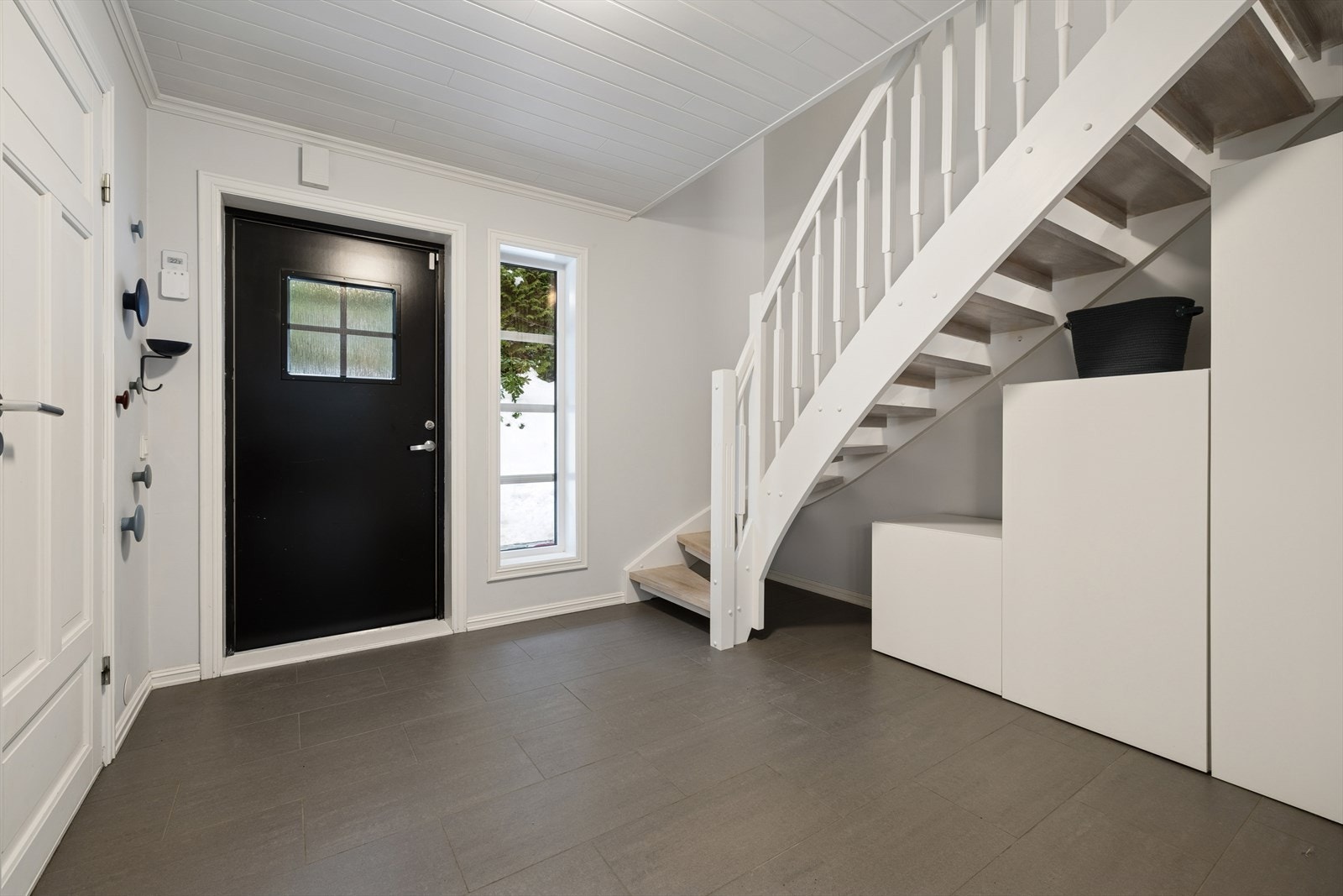 Lys og trivelig hall med flislagt gulv og trappeadkomst til boligens øverste plan, et innbydende førsteinntrykk. Galleribilde