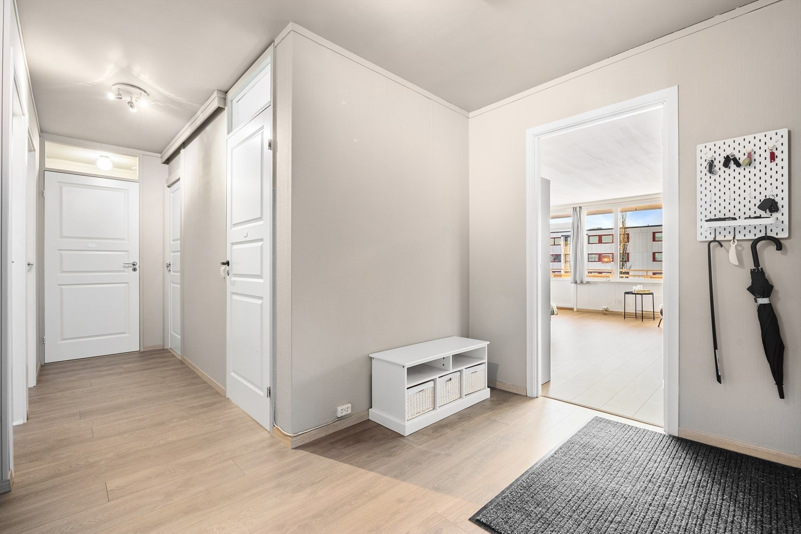 Entréen fungerer som et naturlig knutepunkt i leiligheten. Galleribilde