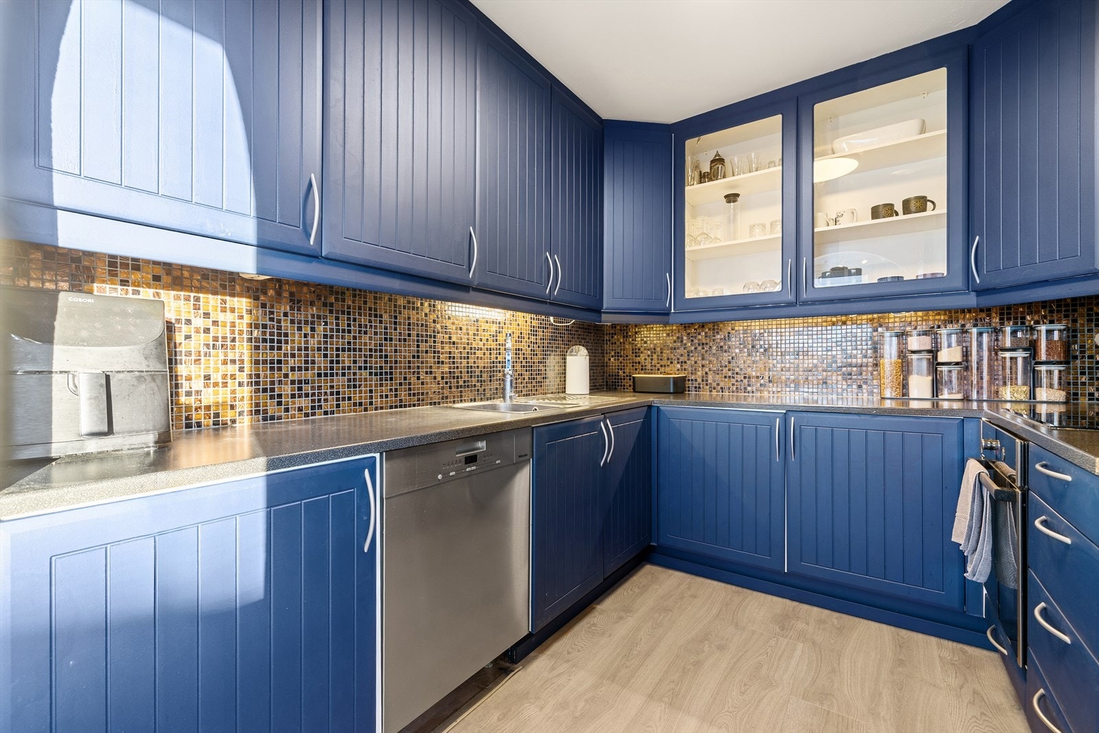 Kjøkkenet har laminat på gulv og flis på vegg over benkeplate. Himlingen har malte overflater. Galleribilde