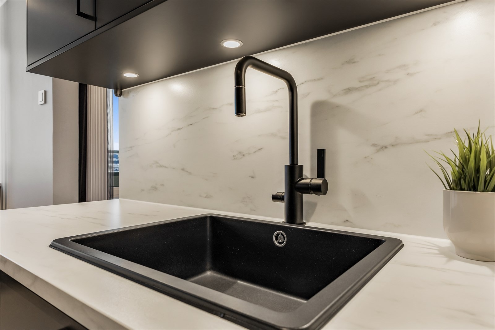 Sort blandebatteri med uttrekk og underlimt vask er både funksjonelt og stilfullt. Galleribilde